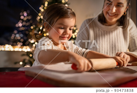 mother and daughter making gingerbread at home 93473838