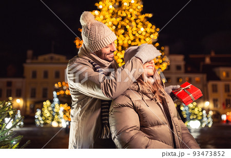 happy couple with gift over christmas lights 93473852
