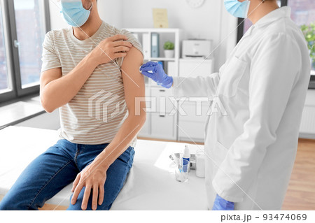 doctor disinfecting patient's skin for vaccination 93474069