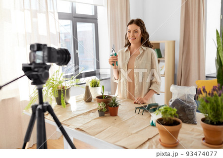 happy woman or blogger planting flowers at home 93474077