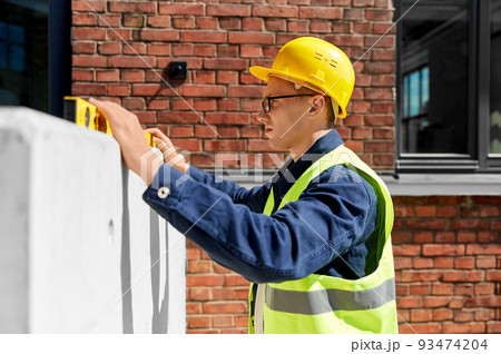 male builder with level measuring wall male builder with level measuring wall 93474204