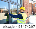 male builder with ruler measuring window 93474207