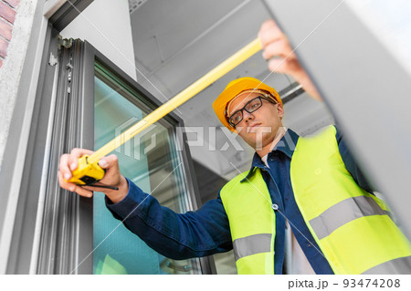 male builder with ruler measuring window male builder with ruler measuring window 93474208