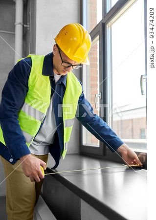 male builder with ruler measuring window sill male builder with ruler measuring window sill 93474209