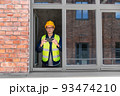 builder with smartphone taking picture at window 93474210