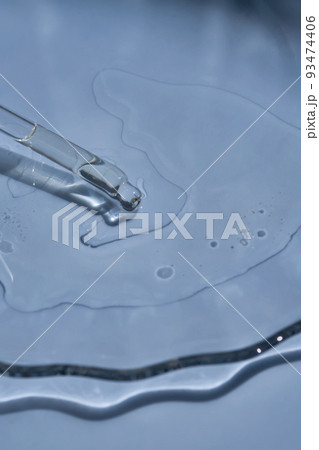 Dropper with serum or cosmetic oil on a blue background. 93474406
