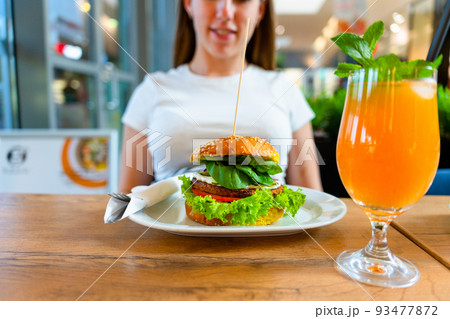 Veggie burger healthy vegan food. Salad, avocado, vegetable on vegetarian hamburger eating cute woman. Vegan sandwich healthy diet food. Veggie burger healthy vegan food. Salad, avocado, vegetable on vegetarian hamburger eating cute woman. Vegan sandwich healthy diet food. 93477872