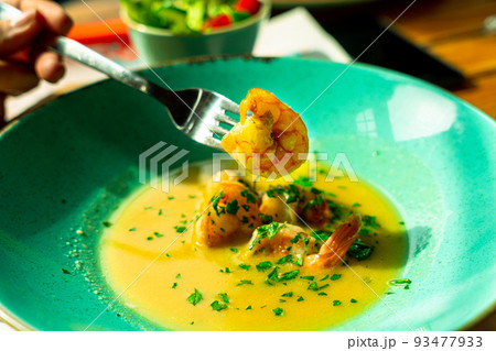 Shrimp soup seafood dish. Thai spicy prawn soup in plate. Thai shrimp curry food with creamy coconut milk. Shrimp soup seafood dish. Thai spicy prawn soup in plate. Thai shrimp curry food with creamy coconut milk. 93477933