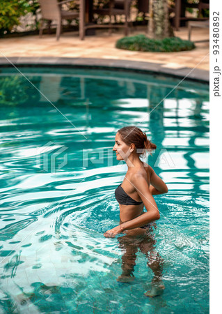 Caucasian girl bathing outside in the pool 93480892