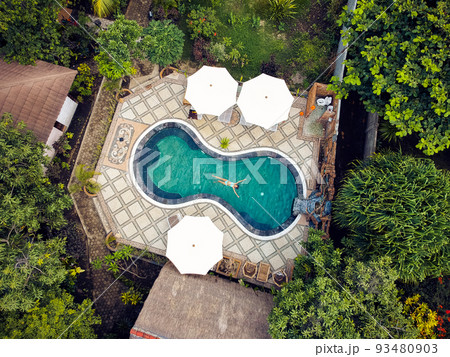 a young girl with pleasure swims in the pool.the view from the top a young girl with pleasure swims in the pool.the view from the top 93480903