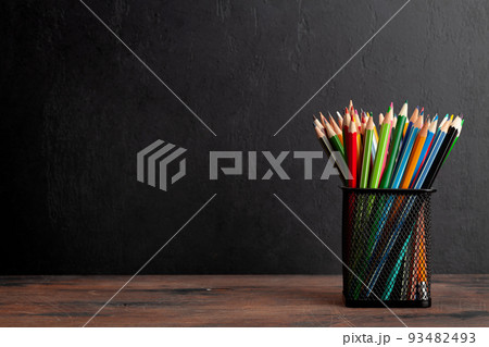 Colorful pencils on wooden table and blackboard Colorful pencils on wooden table and blackboard 93482493