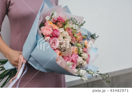 Colorful bouquet of different fresh flowers in the hands of florist woman. Rustic flower background. Craft bouquet of flowers. Colorful bouquet of different fresh flowers in the hands of florist woman. Rustic flower background. Craft bouquet of flowers. 93482971