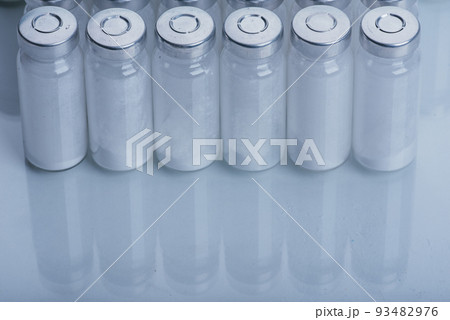 Glass medical ampoule vial for injection. Medicine is dry white drug penicillin powder or liquid with of aqueous solution in ampulla. Close up. Glass medical ampoule vial for injection. Medicine is dry white drug penicillin powder or liquid with of aqueous solution in ampulla. Close up. 93482976