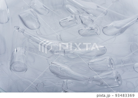 Glass medical ampoule vial for injection. Medicine is liquid sodium chloride with of aqueous solution in ampulla. Close up. Bottles ampule multicolor. Glass medical ampoule vial for injection. Medicine is liquid sodium chloride with of aqueous solution in ampulla. Close up. Bottles ampule multicolor. 93483369