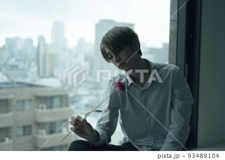 雨の日に窓辺でくつろぐ男性 93489104
