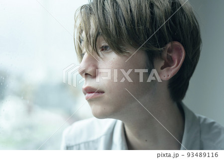 雨の日に窓辺でくつろぐ男性 93489116