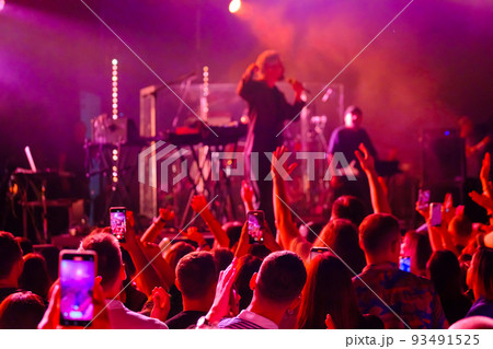 Crowd dancing near stage during concert 93491525