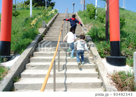 鳥居の階段を走って駆け上がる兄弟 93492343
