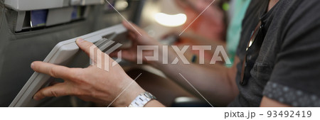 Man in protective medical mask lifting table on airplane seat closeup 93492419