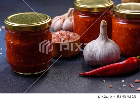 Homemade hot tomato sauce adjika in jars. Tomatoes, chilli pepper, garlic and herbs 93494219