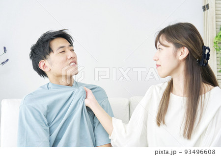女性に胸ぐらをつかまれる男性 93496608