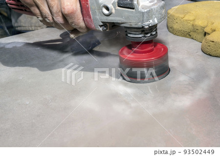 The tiler drills porcelain stoneware with a diamond crown. Close-up, selective focus. 93502449