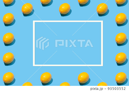 Ripe lemons and empty paper frame on blue background Ripe lemons and empty paper frame on blue background 93503552