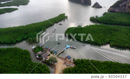 Aerial view of Thai traditional longtail fishing boats at the pier in Phang Nga Bay in the Andaman Sea, Thailand. Top view of many fishing boats floating in the sea among mangrove forest. Aerial view of Thai traditional longtail fishing boats at the pier in Phang Nga Bay in the Andaman Sea, Thailand. Top view of many fishing boats floating in the sea among mangrove forest. 93504337