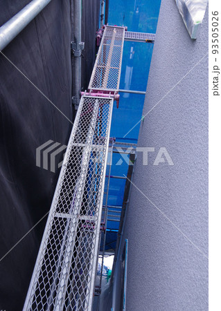 戸建て住宅の外壁塗装　屋根塗装　現場　足場の組まれた家　塗装工事　足場　住宅工事の様子　養生 93505026