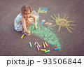 Child from Ukraine draws with chalk. 93506844