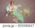 Child from Ukraine draws with chalk. 93506847