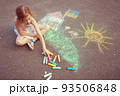 Child from Ukraine draws with chalk. 93506848