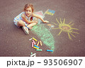 Child from Ukraine draws with chalk. 93506907