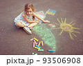 Child from Ukraine draws with chalk. 93506908