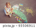 Child from Ukraine draws with chalk. 93506911