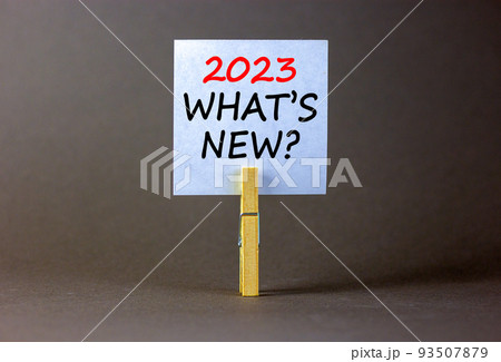 2023 what is new symbol. White paper with words 2023 what is new, clip on wooden clothespin. Beautiful grey table grey background. Business and 2023 what is new concept. Copy space. 93507879