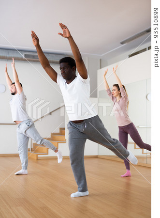 Group of multiethnic people warming up in fitness studio Group of multiethnic people warming up in fitness studio 93510899