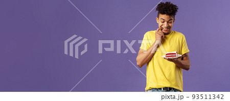 Celebration, party and holidays concept. Portrait of boyfriend cant resist temptation to eat last piece of cake, biting lips and smiling eager to have bite of dessert, hesitating, purple background 93511342