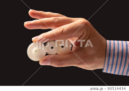 white plastic gears in hand. machine motion transmission mechanism white plastic gears in hand. machine motion transmission mechanism 93514434