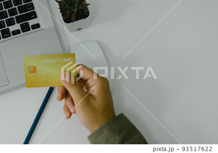 Man holding credit card business finance shopping online payment internet banking on background top view and fat lay. 93517622