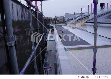 戸建て住宅の外壁塗装　屋根塗装　現場　足場の組まれた家　塗装工事　足場　住宅工事の様子　養生 93518269