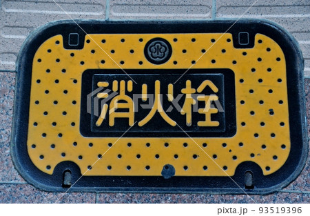 眼につきやすい黄色に塗色された、道路下に設置された消火栓の蓋 93519396