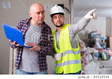 Designer and foreman talking about work in construction site Designer and foreman talking about work in construction site 93520544