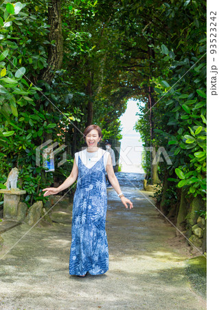 樹齢数百年のフクギの木が並ぶ砂の道を歩く旅ガール、沖縄のパワースポット「フクギ並木」 樹齢数百年のフクギの木が並ぶ砂の道を歩く旅ガール、沖縄のパワースポット「フクギ並木」 93523242