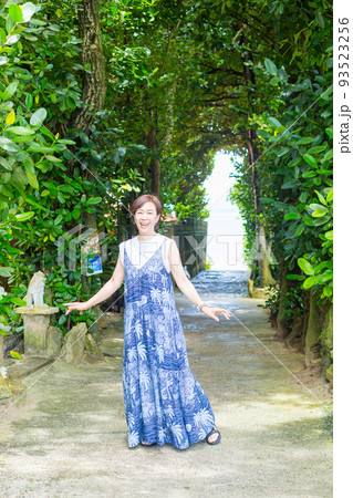 樹齢数百年のフクギの木が並ぶ砂の道を歩く旅ガール、沖縄のパワースポット「フクギ並木」 樹齢数百年のフクギの木が並ぶ砂の道を歩く旅ガール、沖縄のパワースポット「フクギ並木」 93523256