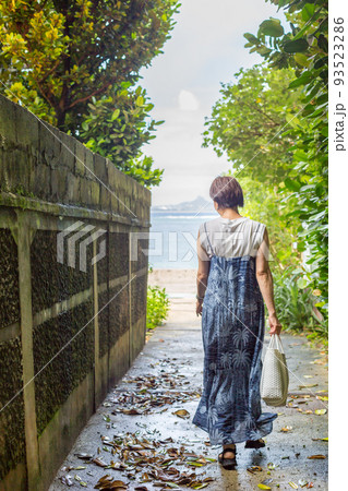 樹齢数百年のフクギの木が並ぶ砂の道を歩く旅ガール、沖縄のパワースポット「フクギ並木」 樹齢数百年のフクギの木が並ぶ砂の道を歩く旅ガール、沖縄のパワースポット「フクギ並木」 93523286