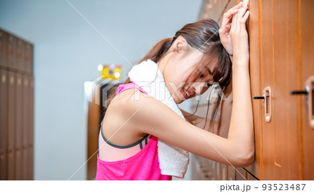 スポーツジムのロッカーで悩む若い女性 93523487