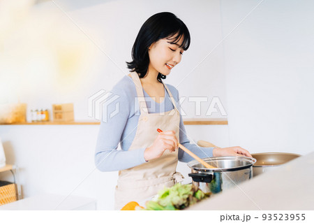 キッチンで料理をする女性 93523955