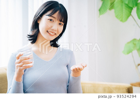 薬を飲む女性 93524294
