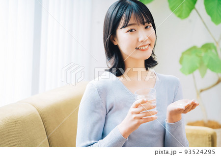 薬を飲む女性 93524295